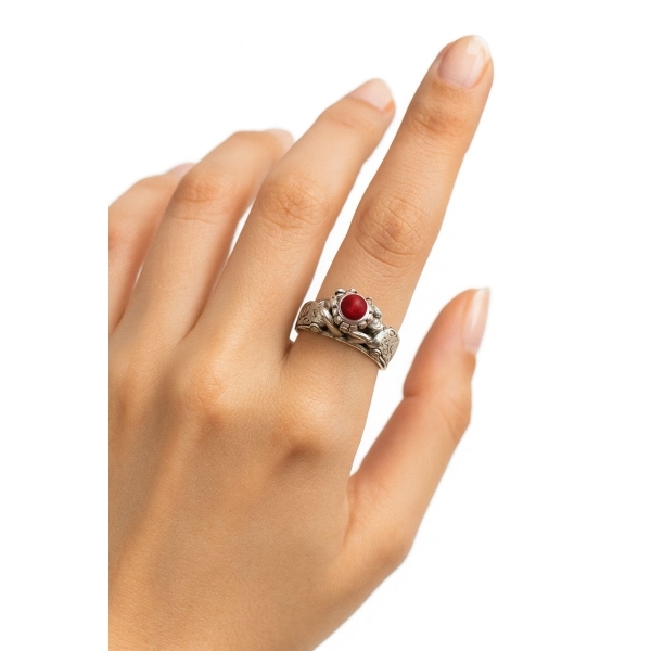 Hand wearing 92.5 silver antique ring with red gemstone and oxidised floral design.”